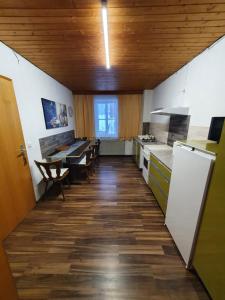 uma cozinha com tectos em madeira e uma mesa e cadeiras em Gästehaus Weißes Lamm - MONTEURZIMMER em Nordhalben