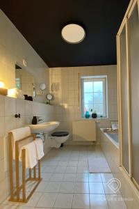 uma casa de banho com um lavatório, um WC e uma janela. em Dichter & Denker em Veimar