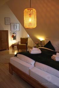 - une chambre avec un lit et une lampe pendant dans l'établissement Dichter & Denker, à Weimar