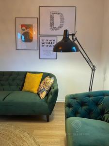 un salon avec un canapé vert et une lampe dans l'établissement Dichter & Denker, à Weimar