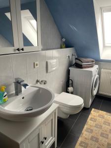 uma casa de banho com um lavatório branco e um WC. em Richter Apartments Finsterwalde em Finsterwalde