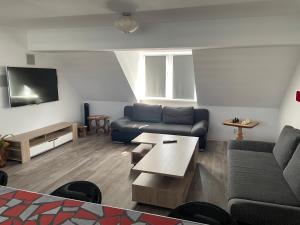 uma sala de estar com um sofá e uma mesa em Richter Apartments Finsterwalde em Finsterwalde