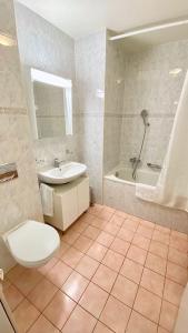 a bathroom with a toilet and a sink and a tub at Close to the lake and very spacious 3 bedroom in Lausanne