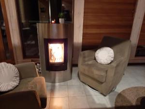 a living room with two chairs and a fireplace at Kiurun Villas in Imatra