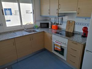 a kitchen with a sink and a stove top oven at Mar azul in Almazora
