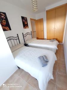 two beds in a room with white sheets at Mar azul in Almazora +11 photos