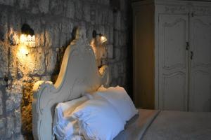 a bed with a white headboard sitting next to a wall at Chigdem Hotel-Special Category in Alaçatı