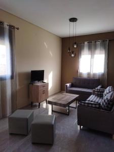sala de estar con sofá y TV en Tzoli Residence, en Kalamaki