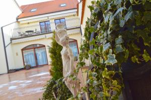 Una statua di una donna in piedi di fronte a un edificio di Hotel Sebastian u Hoffera a Modra