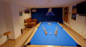 a living room with a pool table with cues at Ferienhaus Hohenaschau in Aschau im Chiemgau