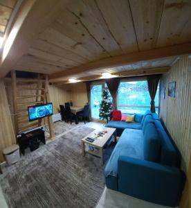 a living room with a blue couch and a tv at kucica na vodi drinski snovi in Mali Zvornik