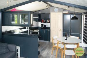 a kitchen and dining room with a table in a tiny house at Chalet/Caravan Camping Resort Heische Tip Zeeland in Zeeland