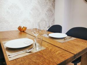 a wooden table with white plates and glasses on it at Apartment Schwarzenbek in Schwarzenbek