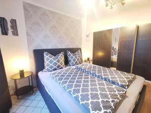 a bedroom with a bed with a blue and white comforter at Apartment Schwarzenbek in Schwarzenbek