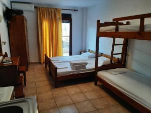 a bedroom with two bunk beds and a window at Hotel Kosmas in Sarti
