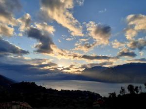 a sunset over a body of water with mountains at Andreis Apartments in Malcesine