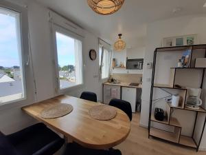 a dining room with a table and a kitchen at Studio calme 20m² à 500 mètres de la plage/ centre in Saint-Pierre-Quiberon