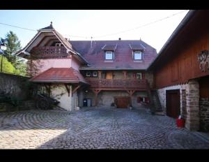 una casa grande con una entrada de ladrillo delante de ella en gite du heidenberg en Osenbach