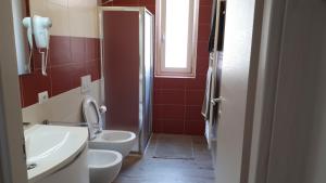 baño con 2 aseos, lavamanos y ventana en appartamentsandreis en Malcesine