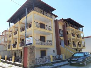 a yellow building with a car parked in front of it at Hotel Kosmas in Sarti