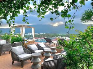 a patio with chairs and tables and a pool at The Mystery Con Dao in Con Dao