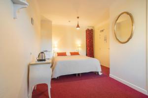 a hotel room with a bed and a mirror at Hôtel Itzalpea in Saint-Jean-Pied-de-Port