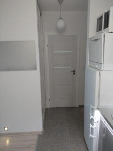 a kitchen with a white refrigerator and a door at Apartament Ziemia Kłodzka in Kłodzko