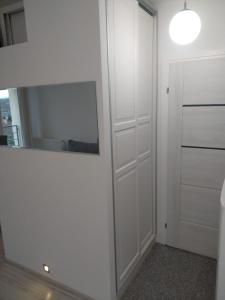 a white room with a mirror and a closet at Apartament Ziemia Kłodzka in Kłodzko