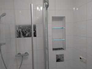 a shower with a glass door and a mirror at Apartament Ziemia Kłodzka in Kłodzko