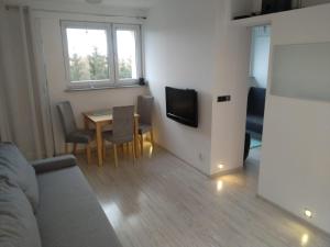 a small living room with a table and a television at Apartament Ziemia Kłodzka in Kłodzko +10 photos