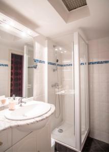 a white bathroom with a sink and a shower at Hôtel Itzalpea in Saint-Jean-Pied-de-Port