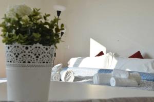 un vase avec une plante sur une table à côté d'un lit dans l'établissement CITY CENTER - LUIGI&CAROLINA APARTMENTS - by Host4U, à Pavia