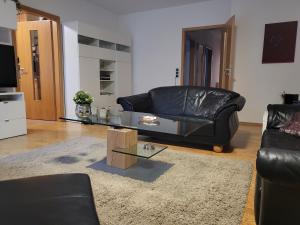 een woonkamer met een leren bank en een salontafel bij Mucki´s Ferienwohnung in Bad Zwischenahn