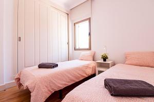 a bedroom with two beds and a window at Casas FreshApartments in Málaga