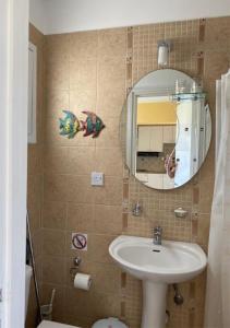 uma casa de banho com um lavatório e um espelho em Cozy Coral Bay Studio by the sea em Coral Bay