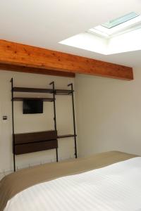 a bedroom with a bed and a television on a wall at A la Suite du Jardin de l'Isle in Vienne