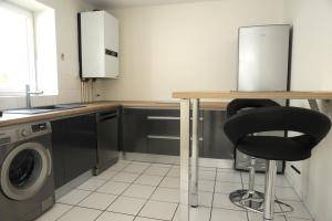 a kitchen with a table and a black chair at A la Suite du Jardin de l'Isle in Vienne