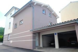 a large white building with a garage at A la Suite du Jardin de l'Isle in Vienne