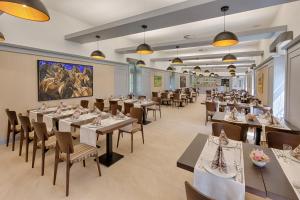 a restaurant with tables and chairs and a large painting on the wall at Wellness a Relax centrum Palárikovo in PalÃ¡rikovo