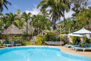 una piscina in un resort con sedie e ombrelloni di Aestus Villas Resort a Diani Beach