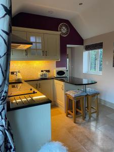 a kitchen with a table and some chairs in it at Wisteria Cottage - Hillside Holiday Cottages, Cotswolds in Warmington