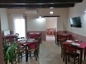 a dining room with red tables and chairs and a tv at La Rocca dei Borboni in Santa Domenica Talao