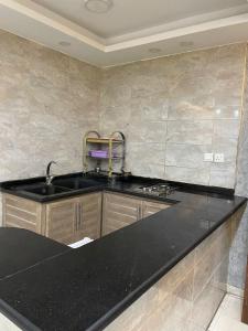 a kitchen with a black counter top and a sink at Aqaba Roza in Aqaba +46 photos