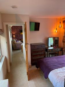 a bedroom with a bed and a table and a desk at Wisteria Cottage - Hillside Holiday Cottages, Cotswolds in Warmington