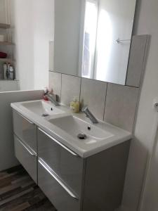 a bathroom with a white sink and a mirror at Appartement de charme avec parking et terrasse in Besançon