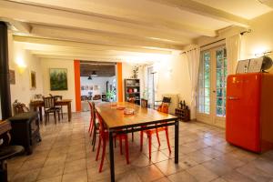 a kitchen with a wooden table and a red refrigerator at Domaine Maison Dodo in Lamonzie-Saint-Martin