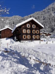 une cabane en rondins dans la neige à l'avant dans l'établissement Haus Mannhart, à Sankt Gallenkirch