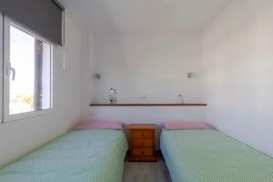 a bedroom with two beds and a sink and a window at Costa Luz Sirens Beach in Los Pocillos