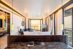 a hotel room with a bed and a living room at Baba Beach Club Hua Hin Luxury Pool Villa by Sri panwa in Cha Am