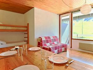 a dining room with a table and a couch at Studio Chamrousse, 1 pièce, 4 personnes - FR-1-340-47 in Chamrousse